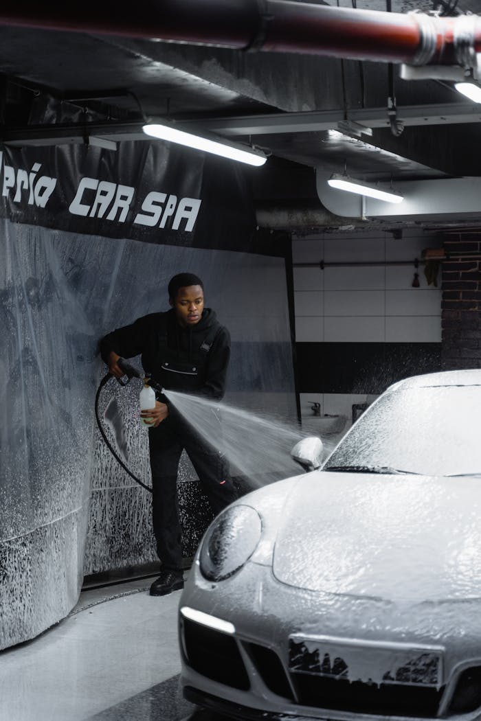 A Man in Black Hoodie Cleaning the Car